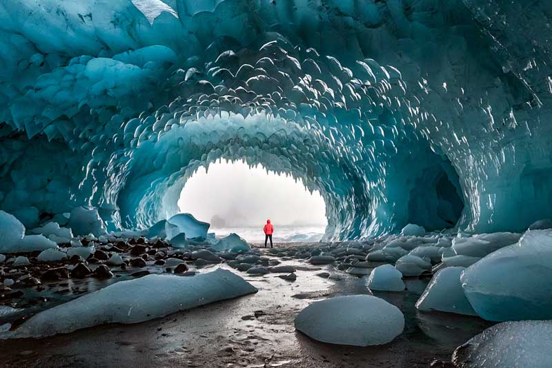Image of a man standing inside a glacier in Iceland.